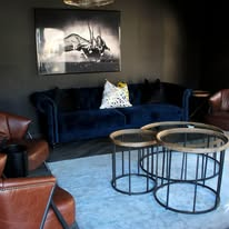 Guest lounge with navy velvet sofa and leather armchairs