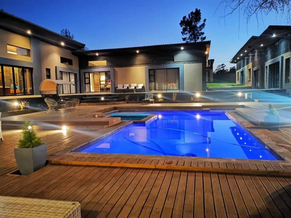 51 On Kologha outdoor pool and jacuzzi at dusk, with warm deck lighting and the guesthouse in the background